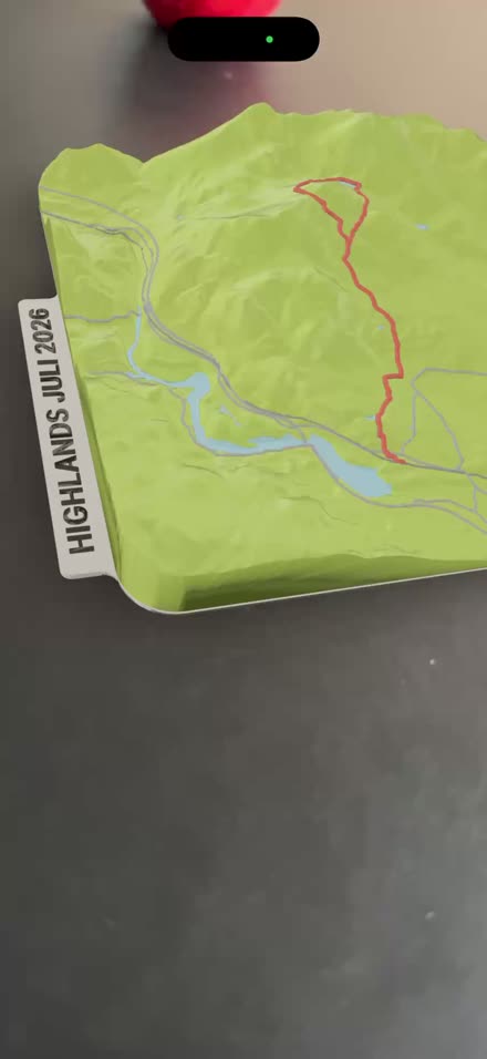 A terrain model of a route in the Scottish Highlands, a custom label along the edge of the disc, shown in augmented reality on an iPhone.